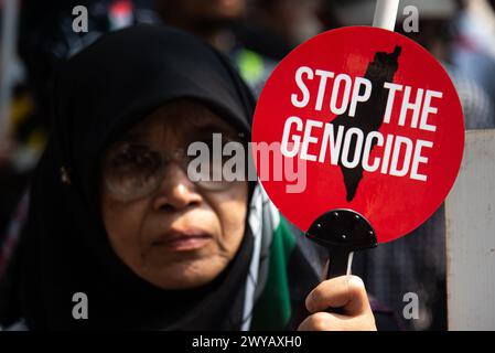 Bangkok, Thailand. April 2024. Ein Demonstrant hält während der Demonstration vor der israelischen Botschaft in Bangkok ein Schild mit der Aufschrift „stoppt den Völkermord“. Pro-palästinensische Demonstranten versammelten sich vor der israelischen Botschaft in Bangkok, um ihre Unterstützung für die Palästinenser im israelisch-Hamas-Konflikt in Gaza zum Ausdruck zu bringen. Quelle: SOPA Images Limited/Alamy Live News Stockfoto