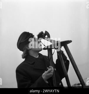 GIRL GUNNERS: DIE ARBEIT DER HILFSKRÄFTE AN EINER EXPERIMENTALSTATION, SHOEBURYNESS, ESSEX, ENGLAND, 1943 - 23-jährige ATS Junior-Commander Joyce Bathurst blickt durch ein Fernglas, während sie Flugabwehrgranaten mit einer Stoppuhr vom Moment des Feuers bis zum Ausbruch abfängt. Sie schickt die Ergebnisse an einen Kollegen, der die Informationen aufzeichnet. Sie arbeitet seit etwa 5 Jahren hier an der Royal Artillery Experimental Station in Shoeburyness. Laut der Originalüberschrift hatte sie gerade ihren Bachelor of Science am University College London abgelegt, als der Krieg ausbrach. Sie wurde gebeten, zu vol Stockfoto