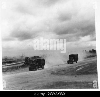 NORMANDIE – VERSCHIEDENE – Originalunterschrift aus der Kriegszeit: Fahrzeuge, die vor kurzer Zeit im Schlamm steckten, schlängeln sich nun entlang der trockenen, erdbedeckten Straßen oder Spuren in Wolken aus erstickendem weißem Staub. Die Bilder zeigen, wie sich der Transport entlang einer neu geschaffenen Umgehungsstraße über Felder bewegt, um Staus auf den Straßen zu verringern. Fotografisches negativ, britische Armee, 21. Armeegruppe Stockfoto