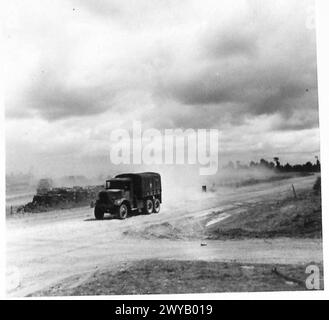 NORMANDIE – VERSCHIEDENE – Originalunterschrift aus der Kriegszeit: Fahrzeuge, die vor kurzer Zeit im Schlamm steckten, schlängeln sich nun entlang der trockenen, erdbedeckten Straßen oder Spuren in Wolken aus erstickendem weißem Staub. Die Bilder zeigen, wie sich der Transport entlang einer neu geschaffenen Umgehungsstraße über Felder bewegt, um Staus auf den Straßen zu verringern. Fotografisches negativ, britische Armee, 21. Armeegruppe Stockfoto