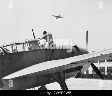 US-FLUGZEUGE FÜR DEN LUFTWAFFENARM DER BRITISCHEN FLOTTE. OKTOBER 1943, ROOSEVELT FIELD, LONG ISLAND, NEW YORK. DIE FLOTTENFLOTTE DER ROYAL NAVY SETZT DIE NEUESTEN FLUGZEUGTYPEN EIN, DIE IN DEN USA GEBAUT WURDEN. EINIGE DER FLUGZEUGE, DIE SICH IN DER PRÜFUNG, VERPACKUNG UND VERSAND AUS DEN USA BEFINDEN. - Ich bereite einen Grumman Tarpon für einen Testflug auf Roosevelt Field vor. Ein „Tarpon“ über Kreisen für die Landung. , Stockfoto