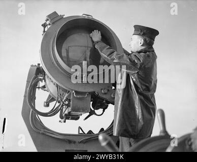 AN BORD DES ZERSTÖRERS HMS ESKIMO. 1942, WÄHREND DES BETRIEBS DER HEIMATFLOTTE. - Reinigen des Suchscheinwerfers an Bord der HMS ESKIMO. , Stockfoto