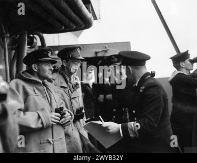 Am 5. September 1943 wird der Kriegskorrespondent J Edgerton Lee auf der Brücke der HMS Duke of York mit dem Wing Commander R J O Compton, DSC, DFC, Admiral Sir Bruce Fraser, KBE, CB und Commander M M Denny, CB, abgebildet. Stockfoto