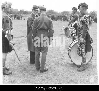 SCHOTTISCHE PFEIFENBAND UNTERHÄLT BEIM FUSSBALLSPIEL - Originaltitel aus der Kriegszeit: Der Bürgermeister von La Delivrande, Jean-Merie Saliou, der die Pipe Band eines schottischen Regiments bei einem Fußballspiel in der Stadt inspiziert. Fotografisches negativ, britische Armee, 21. Armeegruppe Stockfoto