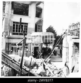 CAEN, WIE ES HEUTE IST [25 GARNISON] - Originalunterschrift aus der Kriegszeit: Trotz der Schäden am Gebäude sind die obersten Stockwerke zerstört und alle Fenster sind aus, die Galleries Lafayette haben immer noch Geschäfte gemacht. Fotografisches negativ, britische Armee, 21. Armeegruppe Stockfoto