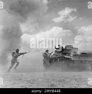 Während des nordafrikanischen Feldzugs 1940–1943 kapitulierte ein Mitglied einer behinderten Panzerbesatzung des deutschen Panzers III, während sich die britische Infanterie dem Panzer näherte. Stockfoto