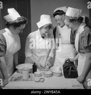 AUSBILDUNG VON QUEEN'S NURSES: AUSBILDUNG VON DISTRICT NURSES AM QUEEN'S INSTITUTE OF DISTRICT NURSES, GUILDFORD, SURREY, ENGLAND, GROSSBRITANNIEN. 1944: in einer Klasse am Queen's Institute of District Nursing demonstriert Sister einer Gruppe von Auszubildenden die Verwendung einer Spritze. Sie spritzt sich einen Apfel, denn aufgrund des Mangels an Kriegszeiten ist sie nicht in der Lage, Orangen zu bekommen, die sie für Demonstrationen benutzte! , Stockfoto