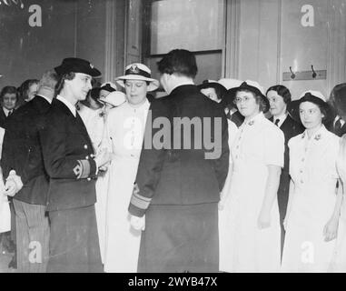 HRH die Herzogin von Kent, der erste Herr der Admiralität, und der Direktor der WRNS treffen eine Gruppe von Wrens, die 1941 für den tropischen Dienst in Singapur ausgewählt wurden. Sie tragen weiße tropische Uniformen. Stockfoto