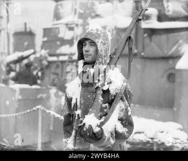 BRITISCHE MARINEAKTIVITÄTEN IM WINTER. 20. JANUAR 1942, ROSYTH, UNTER ARKTISCHEN BEDINGUNGEN. - Ein Gangway Wächter im Dienst am Kai. , Stockfoto