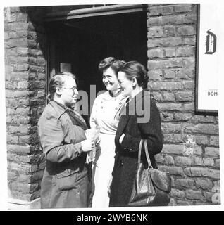 DEUTSCHE ZIVILISTEN LESEN KRIEGSENDE-PROKLAMATION – Originalunterschrift aus der Kriegszeit: Alle Frauen auf diesen Bildern scheinen sehr glücklich mit den Nachrichten zu sein. Fotografisches negativ, britische Armee, 21. Armeegruppe Stockfoto