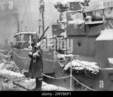 BRITISCHE MARINEAKTIVITÄTEN IM WINTER. 20. JANUAR 1942, ROSYTH, UNTER ARKTISCHEN BEDINGUNGEN. - Ein Gangway Wächter im Dienst am Kai. , Stockfoto