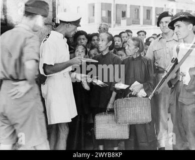 HONGKONG WIEDER BESETZT. SEPTEMBER 1945, SZENEN IN HONGKONG NACH DER WIEDERBESETZUNG DER KRONKOLONIE NACH DER KAPITULATION JAPANS. - Chinesische Kolien, die ihre Pässe überprüfen lassen, bevor sie in Hongkong angestellt werden. Die Pässe wurden ihnen noch vor der japanischen Invasion ausgestellt. , Stockfoto