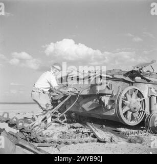 DIE BRITISCHE ARMEE IN NORDAFRIKA 1942 – Ein Offizier der Royal Engineers, der die Wrackteile eines deutschen Panzers PzKpfw III überprüft, wurde am 31. Oktober 1942 gesprengt, um zu verhindern, dass der Feind ihn wiederfindet. Er kreidet einen Buchstaben "E" auf der Rückseite des Tanks - "Vernichtung"! , Stockfoto