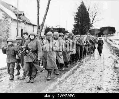 Amerikanische Soldaten werden während der deutschen Offensive im Dezember 1944 von deutschen Truppen in den Ardennen als Gefangene marschiert. Stockfoto