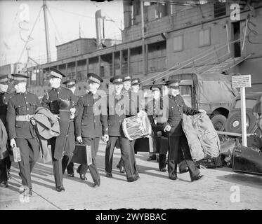 WÄHREND DES ZWEITEN WELTKRIEGS - die Royal Marine Band von HMS COCHRANE reist nach Glasgow, um bei der Eröffnung der Kriegsschiffwoche zu spielen, die im ganzen Land stattfindet, haben viele Städte bereits die Summe des Geldes übertroffen, das sie sammeln wollten. Ein Schiff ist bis zum Kai vor Anker zu sehen. Einer der Männer trägt seine Trommel. , Royal Navy, Royal Marines Band Service, Royal Navy, COCHRANE (HMS) Stockfoto