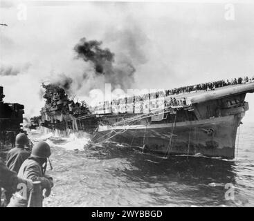 DIE UNITED STATES NAVY WÄHREND DES ZWEITEN WELTKRIEGES - der US Navy Flugzeugträger FRANKLIN in Brand gesetzt und nach dem Angriff von japanischen Kamikaze Flugzeugen vor der Küste Japans aufgelistet. , United States Navy, FRANKLIN (USS) Flugzeugträger (1943) Stockfoto