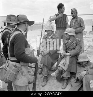 Soldaten der australischen 9. Infanteriedivision bewachen italienische und deutsche Gefangene in Nordafrika nach Rommels erfolglosem Angriff auf Tobruk während des Zweiten Weltkriegs. Stockfoto