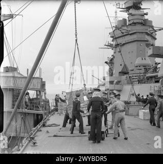 DIE ROYAL NAVY WÄHREND DES ZWEITEN WELTKRIEGS - Provisioning eines Kriegsschiffs der NELSON-Klasse, wahrscheinlich der HMS RODNEY, mit Vorräten für drei Monate. Die Besatzung des Schiffes erhält eine Ladung vom Versorgungsschiff, während andere sich darauf vorbereiten, bereits geladene Vorräte zu verstauen. Das Schlachtschiff hatte eine Besatzung von über 1300 Personen. Royal Navy, RODNEY (HMS) Stockfoto