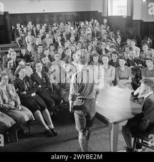 JUGENDVERSAMMLUNG: AUSBILDUNG VON JUGENDORGANISATIONEN, SIDCOT SCHOOL, WINSCOMBE, SOMERSET, ENGLAND, Großbritannien, 1943 - Junge Leute, die an einem einwöchigen Ausbildungskurs an der Sidcot School in Somerset teilnehmen, hören zu, wie ein Mitglied der Boy Scout Movement spricht und die Ziele und Methoden seiner Organisation erklärt. , Stockfoto