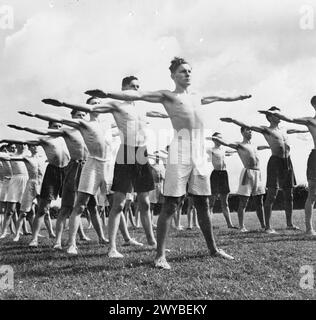 JUGENDVERSAMMLUNG: AUSBILDUNG VON JUGENDORGANISATIONEN, SIDCOT SCHOOL, WINSCOMBE, SOMERSET, ENGLAND, Großbritannien, 1943 - Jungen zeigen körperliches Training während des einwöchigen Jugendtrainings in der Sidcot School in Somerset. In Reihen stehend, sind ihre Arme in der Sonne ausgestreckt. , Stockfoto