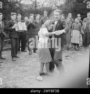 DIE VERTRIEBENEN UND FLÜCHTLINGE IN DEUTSCHLAND - Musik und Tanz beim Warten auf den Transport im British Military Government Centre for Liberated POWs in Sulingen. Die Menschen auf dem Bild sind Polen und Jugoslawien, Zwangsarbeiter, die aus der deutschen Gefangenschaft entlassen wurden. Im Vordergrund tanzt ein polnisches Mädchen, Irena Dziuba aus dem schlesischen Dorf Wilkowiecko, mit einer ihrer Gefährten. Die lächelnde Dame ganz rechts im Hintergrund ist ihre Mutter und ein Akkordeonspieler ist ihr Bruder Tadeusz. , Britische Armee Stockfoto