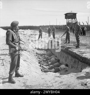 DIE BEFREIUNG DES KONZENTRATIONSLAGERS BERGEN-BELSEN, APRIL 1945 - die deutschen SS-Wärter, die von ihrer Zwangsarbeit erschöpft sind, die Leichen der Toten zu säubern, dürfen von britischen Soldaten eine kurze Pause einlegen, müssen sie aber mit dem Gesicht nach unten in einem der leeren Massengräber liegen. 20. April 1945. , Britische Armee Stockfoto