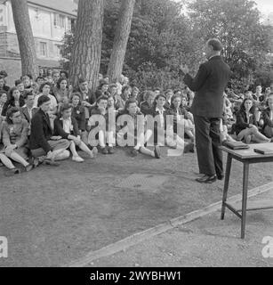 JUGENDVERSAMMLUNG: AUSBILDUNG VON JUGENDORGANISATIONEN, SIDCOT SCHOOL, WINSCOMBE, SOMERSET, ENGLAND, Großbritannien, 1943 - Junge Menschen aus verschiedenen Jugendorganisationen beginnen den Tag mit einem Freiluftgottesdienst unter der Leitung des Assistenzbischofs von Bath and Wells, Bischof Sara. Sie sitzen auf dem Gras im Schatten einiger Bäume, und einige der Schulgebäude sind hinter ihnen sichtbar. , Stockfoto