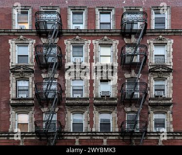 Typisches Wohngebäude auf der Lower East Side (Mietshaus mit Feuertreppe, Fenstern, Lampenpfosten) Detail (roter Backstein) Stockfoto