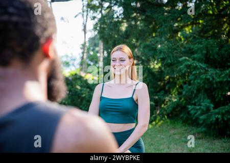 Eine Frau in einem grünen Tanktop lächelt einen Mann an. Der Mann trägt ein schwarzes Hemd Stockfoto