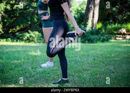 Nahaufnahme der Beine einer Frau, die sich während eines Workouts dehnt. Stockfoto