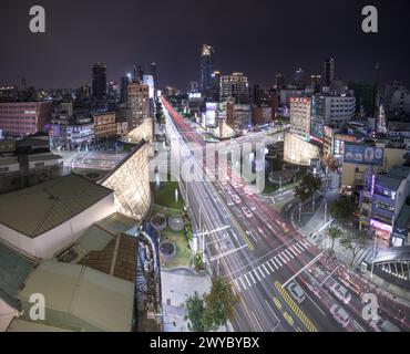 Mit Blick auf eine geschäftige Kreuzung des Formosa Boulevard fängt die lange Exposition das pulsierende Leben und den Verkehr einer modernen Stadt bei Nacht ein Stockfoto