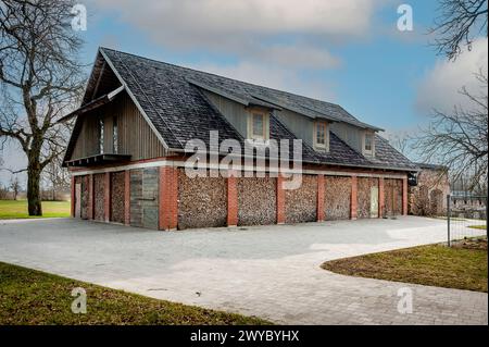 Eine alte Scheune oder ein Schuppen wurde benutzt, um ein Sommerhaus mit Wänden aus Brennholz zu bauen. Baumaterialien: Holz, Baumstämme, Holz, Ziegel. Lage in Zemgal Stockfoto