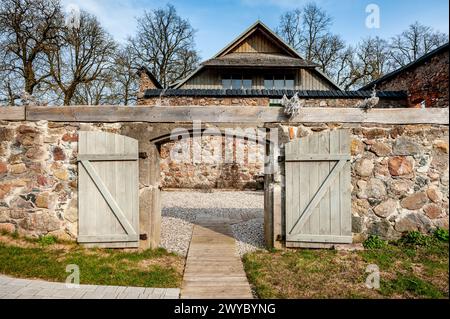 Öffnen Sie das hölzerne Tor, alte Dorfscheune. Der gepflasterte Weg führt zum Innenhof. Stockfoto