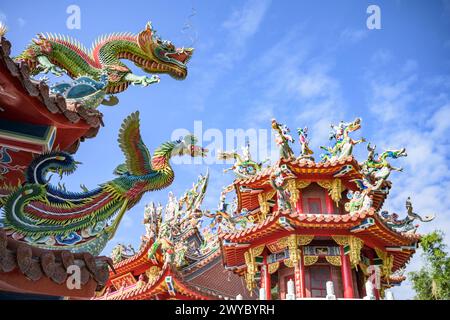 Farbenfrohe und komplizierte Drachenskulpturen schmücken das Dach eines traditionellen taiwanesischen Tempels vor klarem Himmel Stockfoto