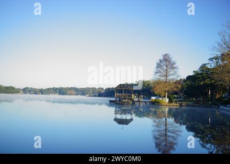 Ruhiger Morgen am Crescent Lake in Brent, Pensacola, mit ruhigem Wasser, das sich am 3. April 2024 in einem Pavillon widerspiegelt. Stockfoto