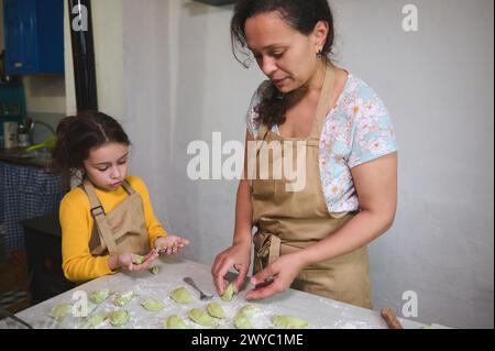 Mutter und Tochter kochen ukrainischen Varennyky in der Küche, bereiten Abendessen nach traditionellem Familienrezept zu. Menschen. Kulinarisch. Essen A Stockfoto