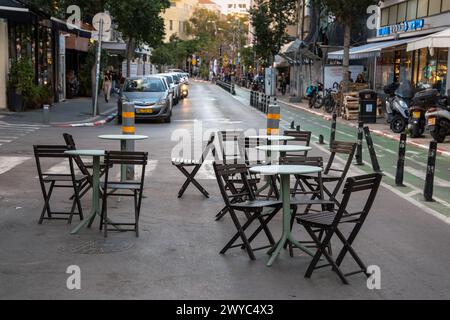 Tel Aviv, Israel - 29. März 2024. Tische und Stühle eines Straßencafés stehen auf der Straße in der Tel Aviv Street Stockfoto