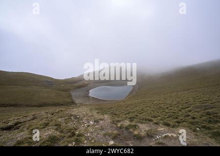 Ein ruhiger Jiaming-See, eingebettet in Berge, im Winter in Nebel gehüllt Stockfoto