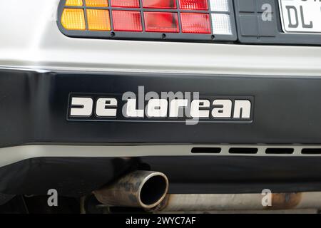 Das DeLorean-Logo zeigt das legendäre Oldtimer-Äußere. Emblem am Karosserieteil des hinteren Stoßfängers über dem Auspuffrohr. Stockfoto