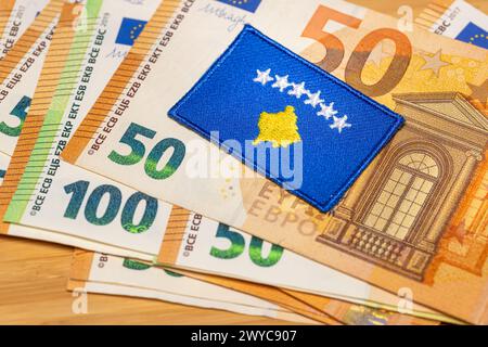 Die Flagge des Kosovo vor dem Hintergrund der gemeinsamen Währung der Europäischen Union, das Konzept des Beitritts des Kosovo zur Eurozone, Nahaufnahme Stockfoto