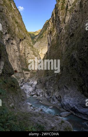 Ein dramatischer Blick auf die enge Taroko-Schlucht mit steilen Klippen, einem fließenden Fluss und einer abgeschiedenen Straße Stockfoto