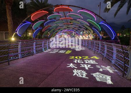 Farbenfroher beleuchteter Bogengang mit 2024-Jahres-Projektionen und chinesischen Schriftzeichen bei Nacht Stockfoto