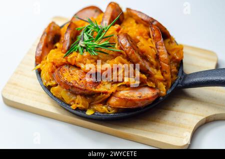 Traditionelles polnisches Gericht namens Bigos aus Sauerkraut, Wurst und Pilzen, das in einer gusseisernen Pfanne warm serviert wird Stockfoto