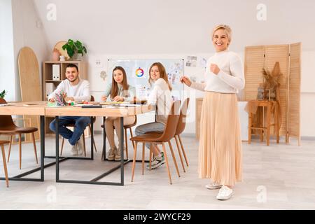 Reifer Kunstlehrer hält Vorlesungen für Schüler in der Schule Stockfoto