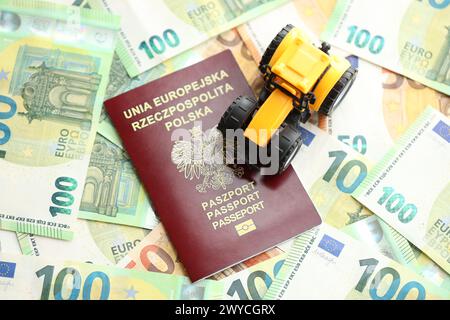 Roter polnischer Pass und gelber Traktor auf Euro-Geldscheinen aus nächster Nähe Stockfoto