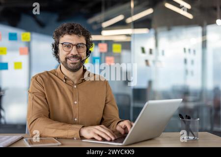 Zielgerichtete Einzelperson, die an einem geschäftlichen Videoanruf mit einem Laptop in einer modernen Büroumgebung teilnimmt. Stockfoto