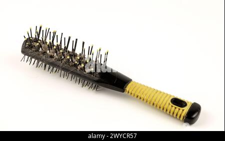 Eine runde Haarbürste. Schmutzige Haarbürste auf weißem Hintergrund. Das Konzept des Haarausfalls. Stockfoto