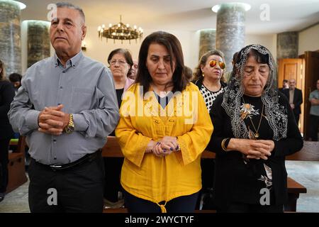 Mossul, Irak. April 2024. Irakische Christen nehmen an der Messe in der 80 Jahre alten chaldäisch-katholischen Kirche um al-Mauna, „unsere Lieben Frau der ewigen Hilfe“, in Mossul im Nordirak Teil. Mit freudigem Beifall und Ululationen feierten die irakischen Christen die Restaurierung der Kirche am 5. April mit einer Heiligsprechungs- und Weihungszeremonie, Jahre nachdem der IS sie in ein religiöses Polizeiamt und ein Autobombenzentrum verwandelt hatte. (Foto: Ismael Adnan/SOPA Images/SIPA USA) Credit: SIPA USA/Alamy Live News Stockfoto