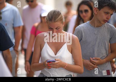 Athen: Eine junge Frau, die auf ihr Handy in der Ermou-Straße schaut. Griechenland Stockfoto