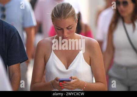 Athen: Eine junge Frau, die auf ihr Handy in der Ermou-Straße schaut. Griechenland Stockfoto